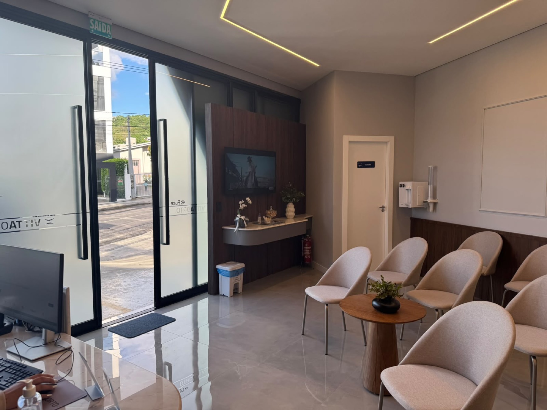 Sala de espera da VittaOrto com poltronas claras e entrada no nível da rua